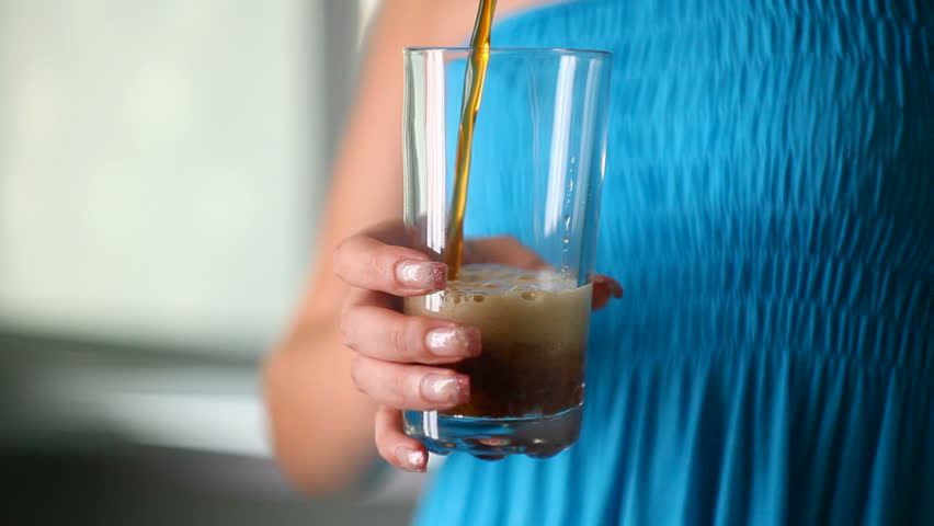 Girl is poured glass of fizzy lemonade