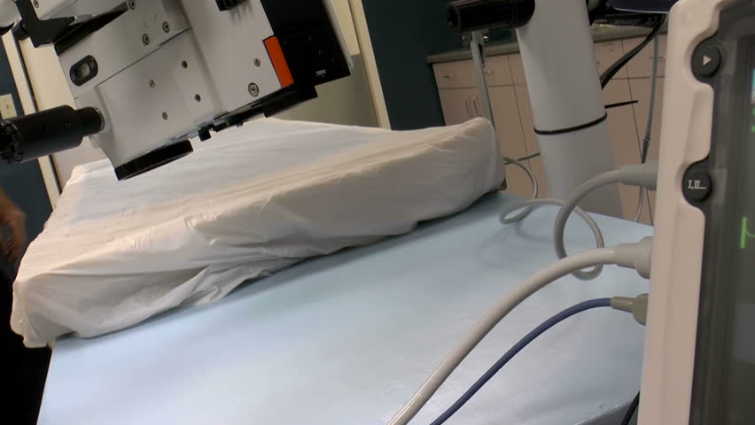 Medical assistant switches on surgical lights, checks, repositions medical equipment in surgery suite before next patient arrives for operation. 1080p