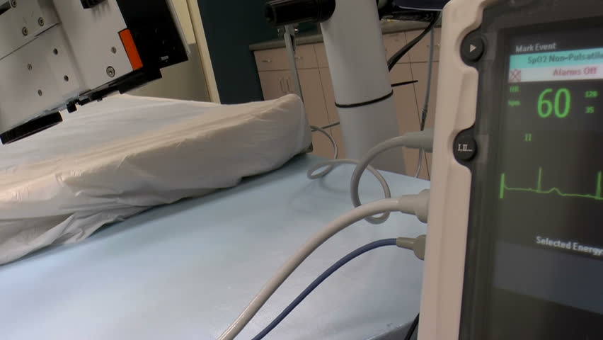 Biomedical technician switches on surgical light, EKG display monitor, checks, tests, equipment in operating room. 1080p