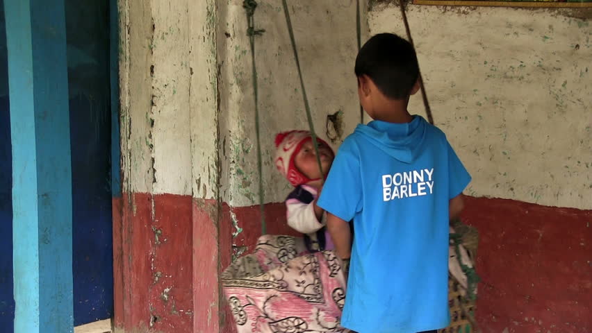 ANNAPURNA REGION, NEPAL â CIRCA OCTOBER 2011 â Little nepali boy in swing and his brother circa October 2011 in Annapurna region in Nepal.
