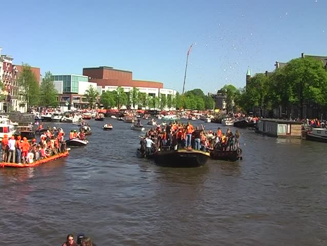 Large dutch celebrating orange crowd on a boat during queensday in Amsterdam Netherlands