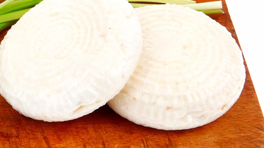 dairy food : feta white cheese cubes on cut wooden plate isolated over white background