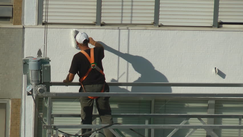 Construction worker on scaffolding repairing the building
