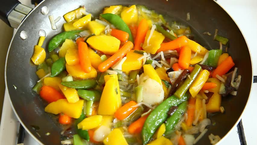 Turning water over and stirring various vegetables cooked in oil