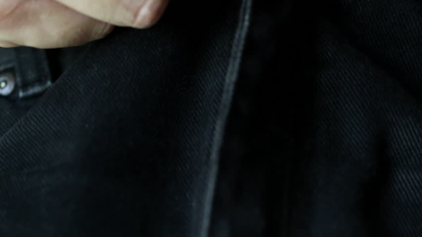 Zipping up the fly on a pair of black denim jeans. Shot with a macro lens and shallow depth of field.