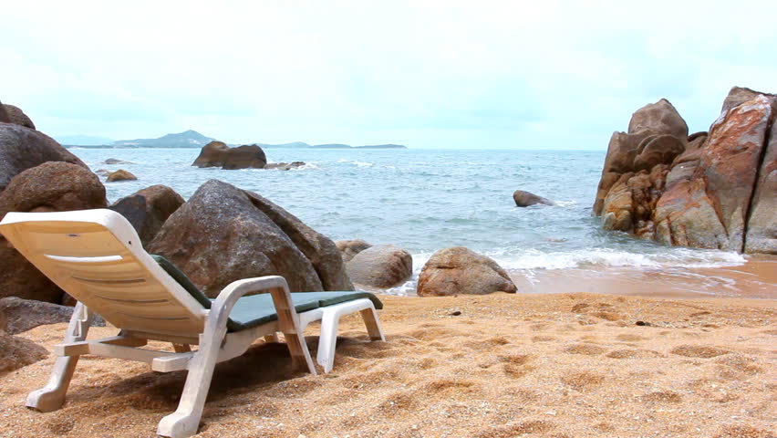 Sunbed near water on a sandy beach