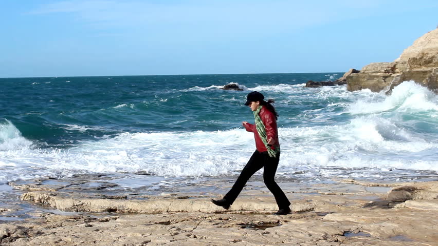Loving the waves - Woman hopping on the coast. 