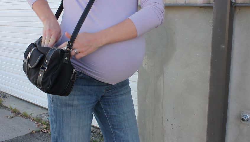 Pregnant woman pulls a revolver handgun from her hand bag