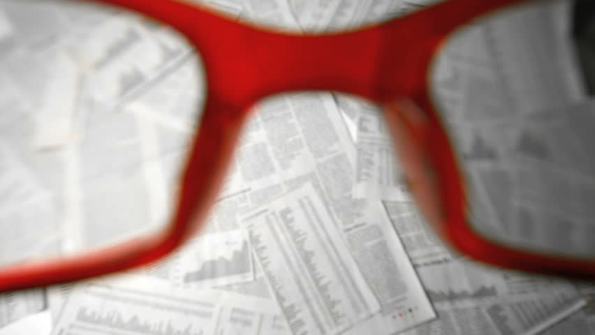 Glasses falling and bouncing on papers with numbers and graphs in slow motion