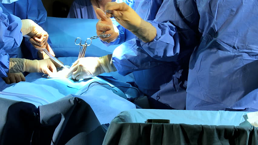 Doctor wearing protective clothing performing surgery using sterilized equipment