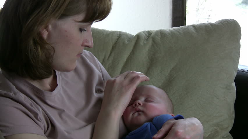 Mother Caressing Baby while he sleeps in her arm.  hd 1080i