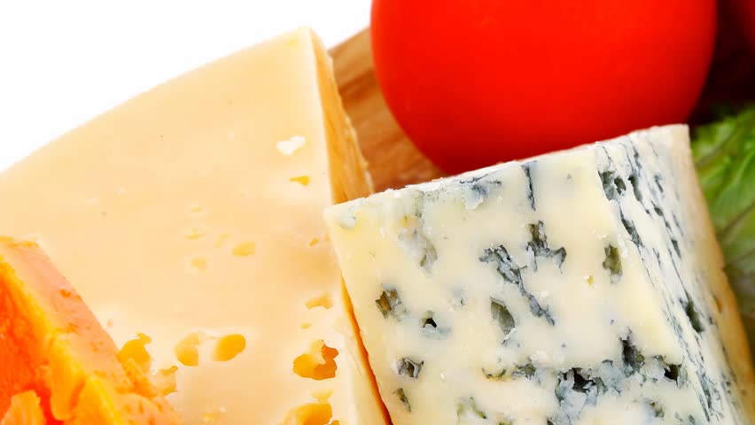 soft feta cheese with aged delicatessen cheeses on cutting wooden plate with tomatoes bread and olive oil 