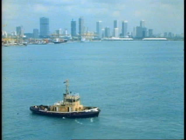 The skyline of Singapore from the harbor with a tug boat, 1982