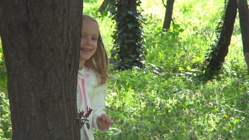 Little Girl Hiding behind Tree, Child Playing Hide and Seek in Forest, Children
