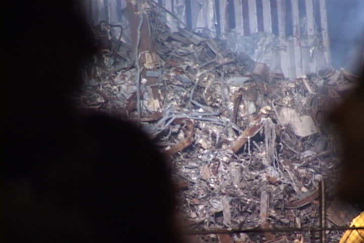 NEW YORK CITY - SEPTEMBER 28, 2001: Emergency vehicle passes World Trade Center rubble behind the silhouetted heads of spectators.