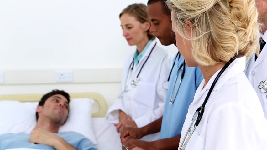 Medical team taking care of a patient lying in the bed