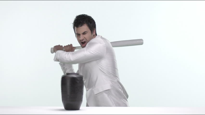 Stress concept. Crazy man in tuxedo breaks fancy vase. Isolated Slow Motion. 