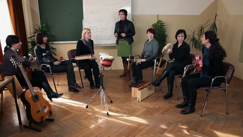 Right to left pan shot of the group of students that are learning a new song in music class