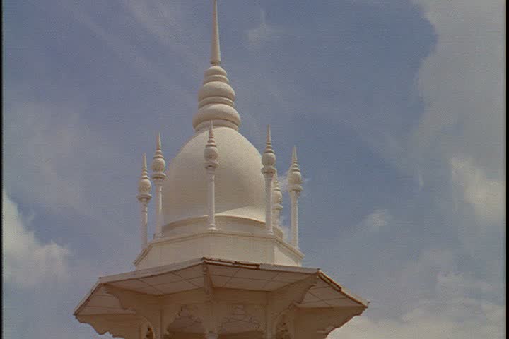 KUALA LUMPUR - CIRCA OCTOBER 1999: CU white onion dome, camera tilts down to minarets over the main entrance to the railway station.