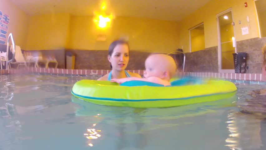 Underwater shot of a cute little baby boy at the swimming pool with his family.