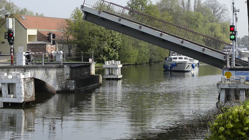 BRUGES, BELGIUM - 3 MAY: Boats go under the Gentpoort drawbridge. The drawbridge was built in 1978 over the old 15th century bridge. Bruges, Belgium. 3 May, 2013