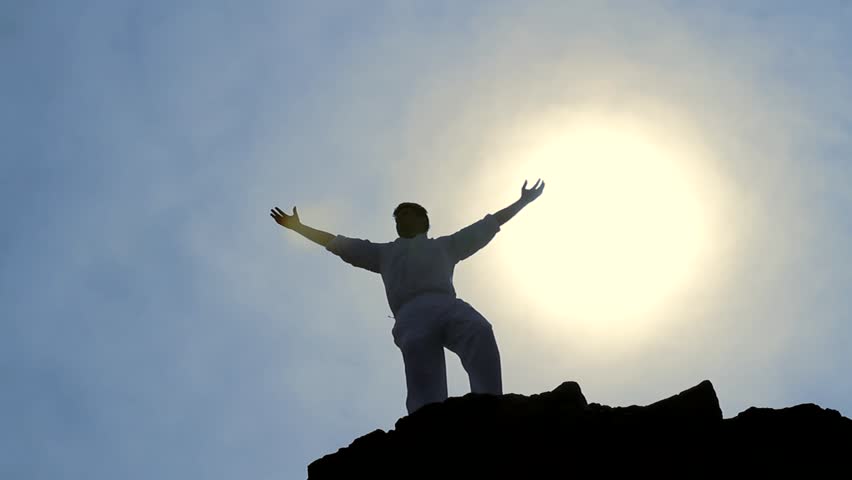 Victory Pose by Man on Top of Hill Lifting Hands at the Sun Business Background