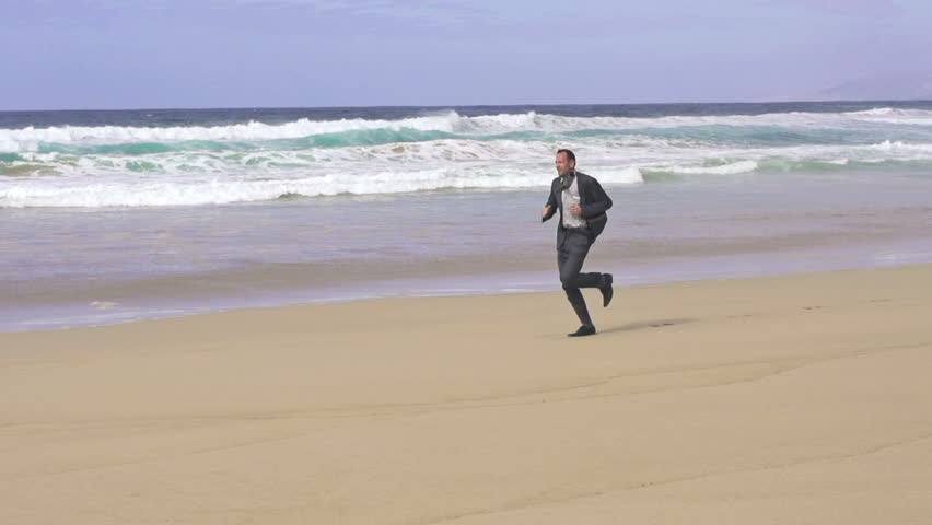 Businessman jogging on beautiful beach
