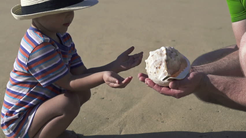 Father and son with beautiful seashell, super slow motion, shot at 240fps
