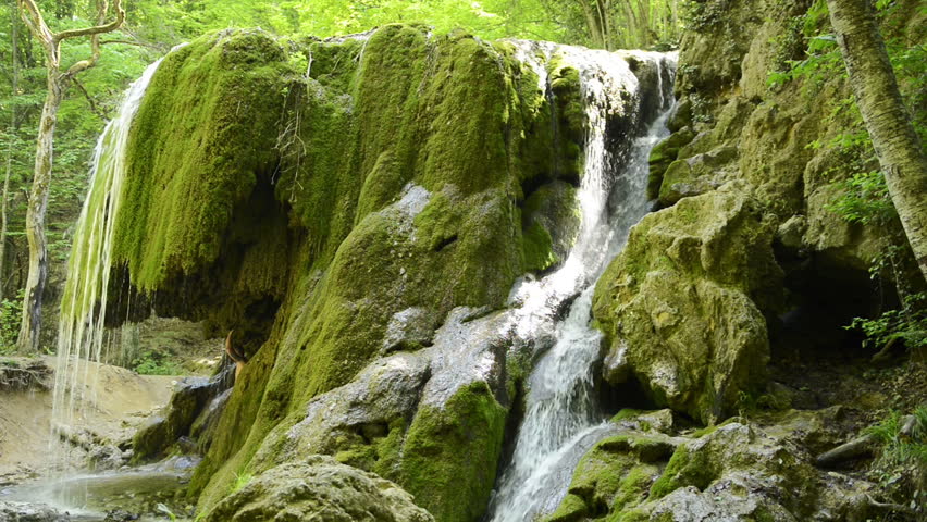 Man in a grotto under a waterfall