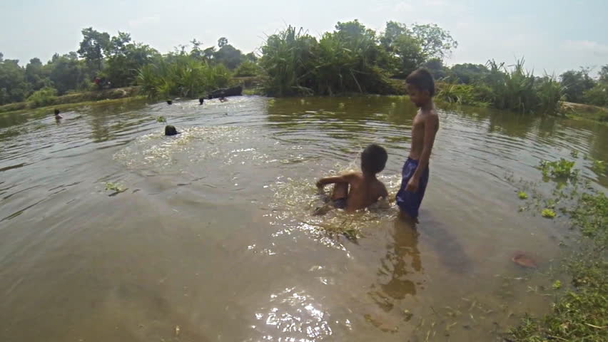SIEM REAP, CAMBODIA - MAY 17: Cambodian kids playing in the water close to Angkor Thom  in Siem Reap Cambodia on May 17th 2013. Recorded at slow motion 120fps