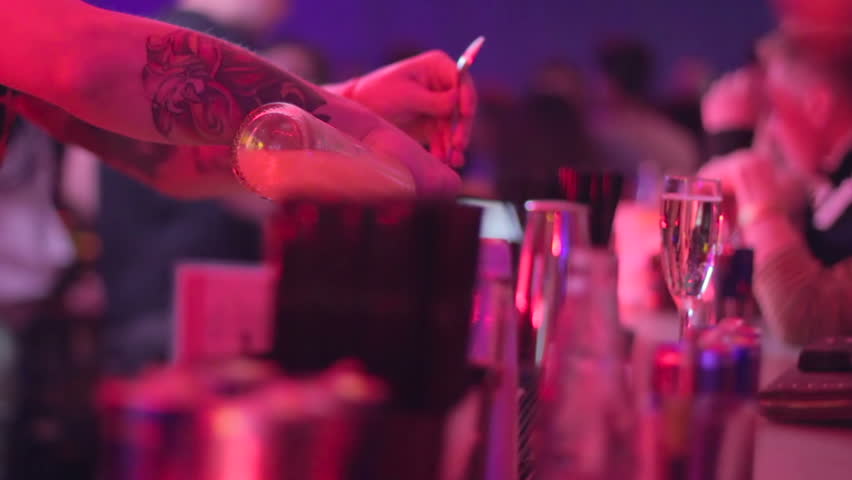 Barternder serving drink for visitors, orange juice and vodka alcohol