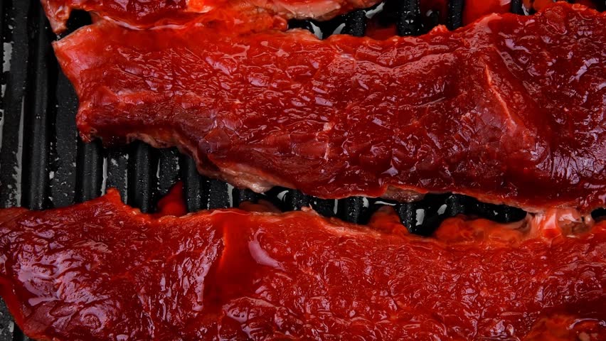 fresh raw bloody beef steaks on black grill plate 1920x1080 intro motion slow hidef hd