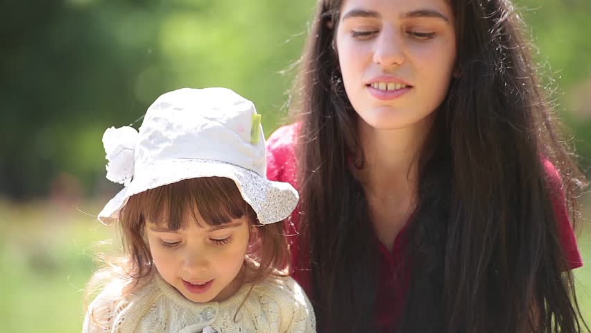 Young adult mother and daughter sing and hug together.
