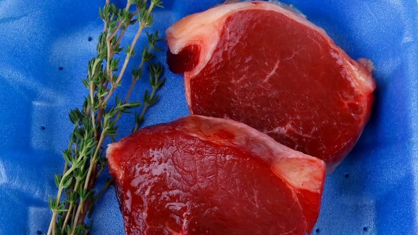 uncooked raw beef fillet with thyme twig on blue tray 1920x1080 intro motion slow hidef hd