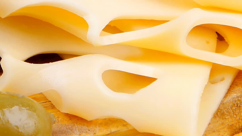 gold swiss cheese sliced on wooden platter with olives and tomato 1920x1080 intro motion slow hidef hd