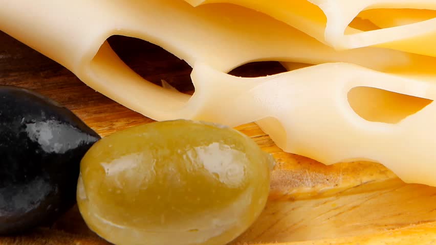 gold swiss cheese sliced on wooden platter with olives and tomato 1920x1080 intro motion slow hidef hd