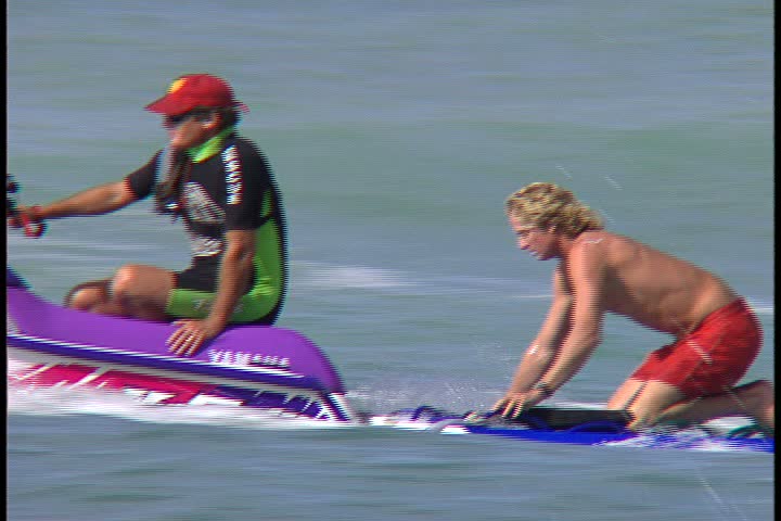 WAIKIKI BEACH, HONOLULU, HAWAII - JANUARY 30, 1997: scenic b-roll shots from Waikiki Beach, Hawaii: man on Jet Ski tows surfer through waves.