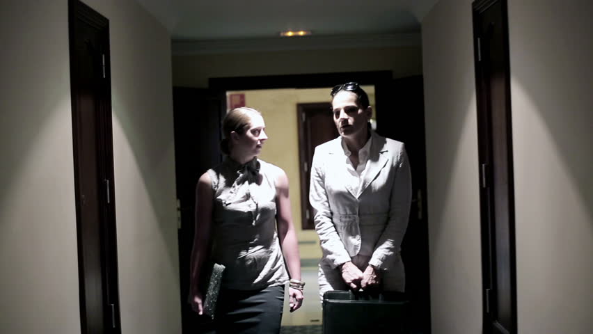 Two businesswoman walking along corridor and talking
