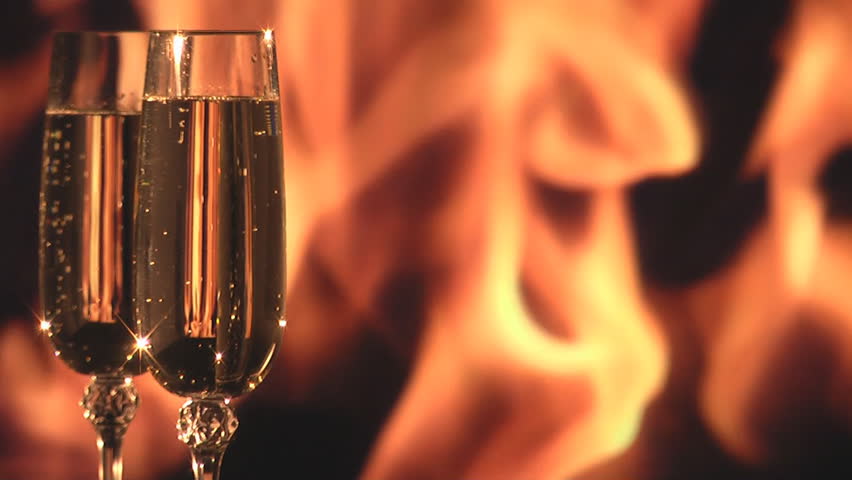 Two wine glasses is highlighted by the fireplace. Perfect seamless loop background.