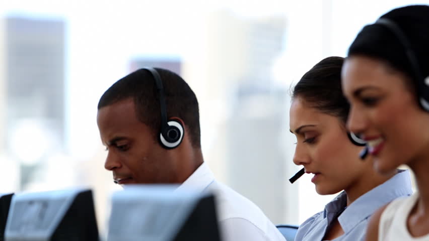 Group of agents in a call centre smiling and helping people