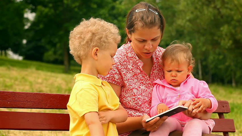 mother and two children, reading and watching Tablet Computers