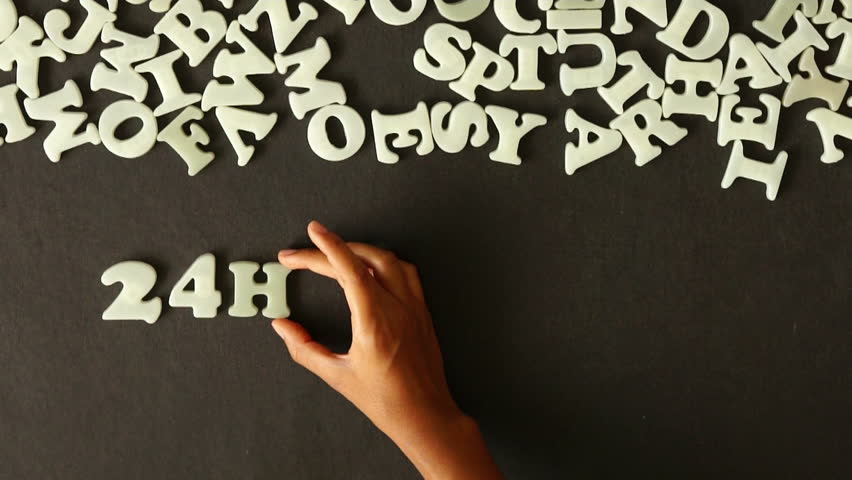 A person spelling 24 Hour Service with plastic letters