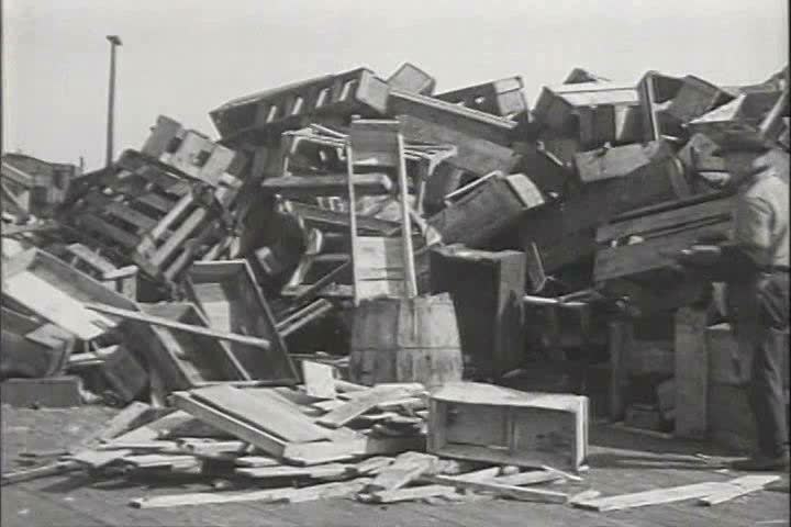 1910s, 1920s - A cigarette starts a fire and a man puts out a fire at a yard filled with wooden pallets