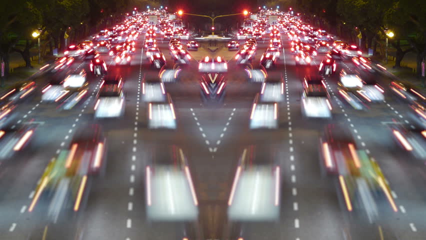 Traffic in the city. Avenue Time-Lapse, symmetric / mirrored, Night. Moon going down. Heavy traffic / jam / flowing with blurred motion.
