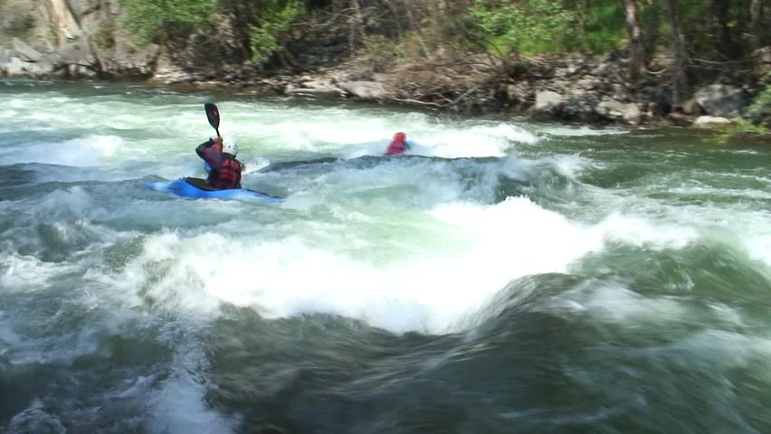 1080i, not rendered: Two man with hydrospeed and one kayak drifting on whitewater.  The camera follows the action. Tripod.