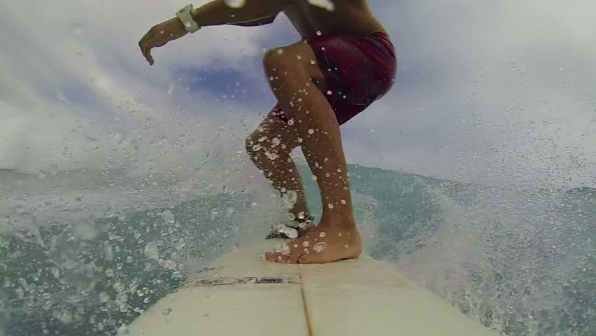 In The Distance A Surfer Uses A Paddle To Catch A Ride On A Small Wave