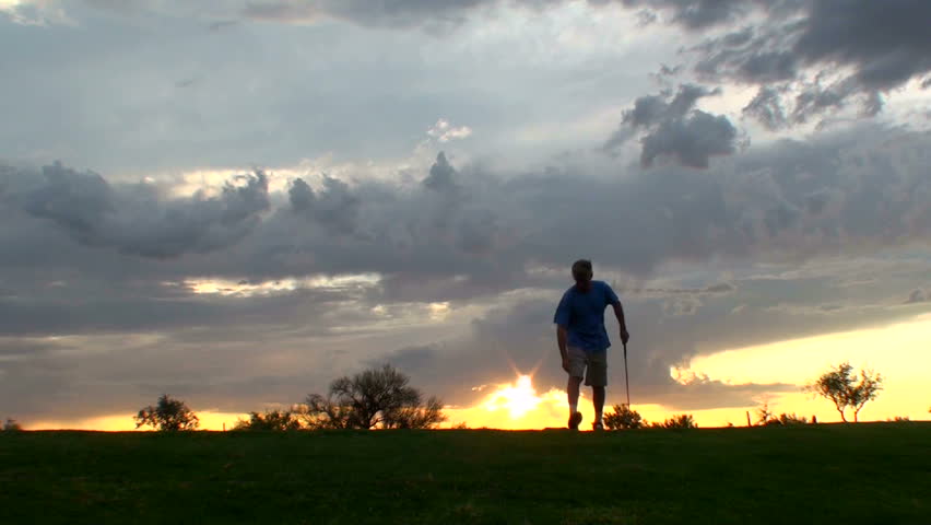 Golfer tees off at sunset. 1920x1080