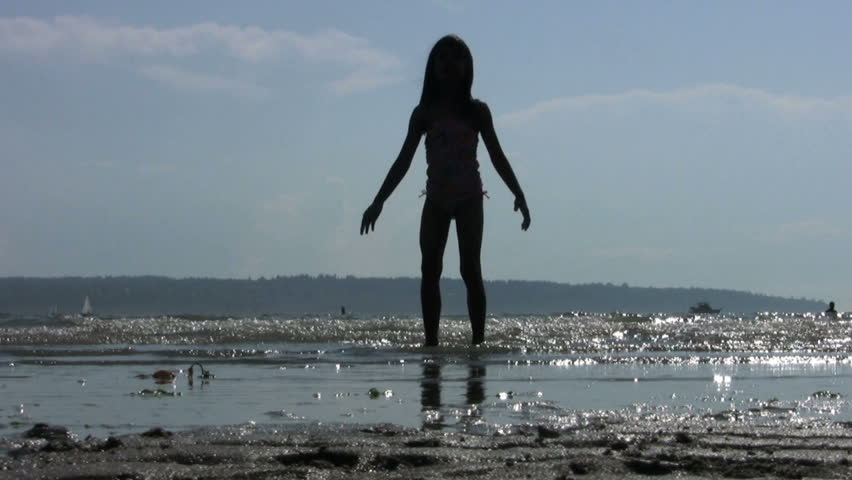 A little girl dancing and doing ballet in the surf on a glorious sunny summer afternoon.
