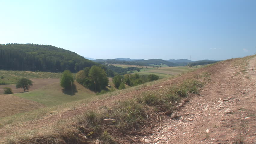 male and female runner running up hill passing the camera