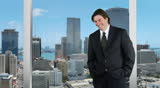 Young businessman standing off center - skyline background